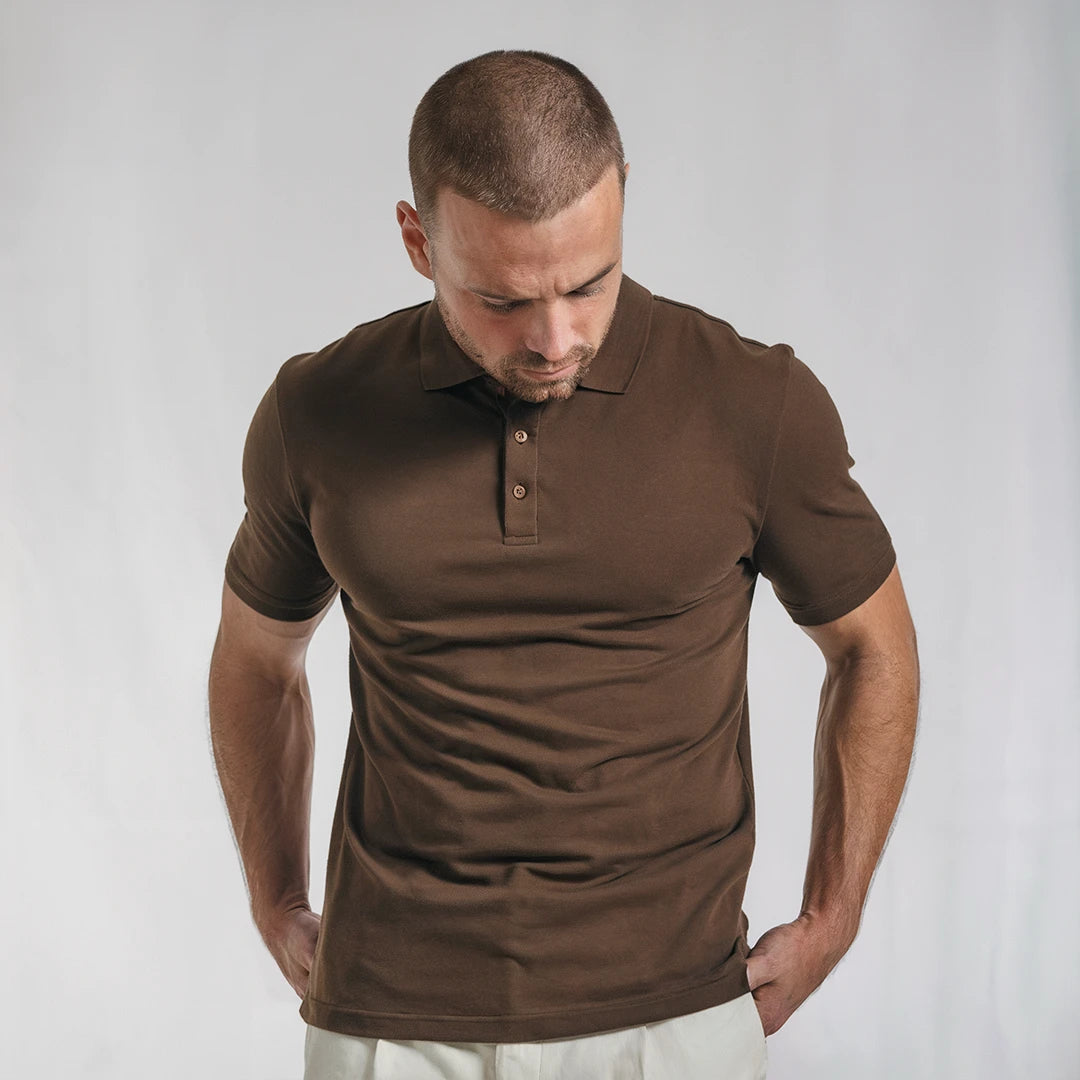 A man wearing a brown French Polo T-Shirt with short sleeves, a collar, and button-up neck.