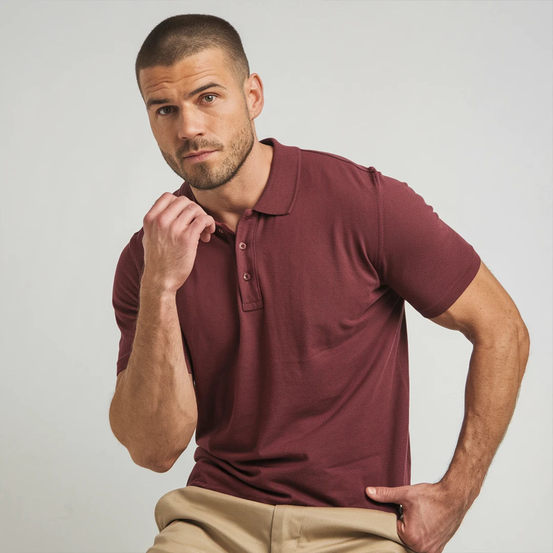 A man wearing a maroon French Polo T-Shirt with short sleeves, a collar, and button-up neck.