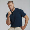 A man wearing a navy French Polo T-Shirt with short sleeves, a collar, and button-up neck.