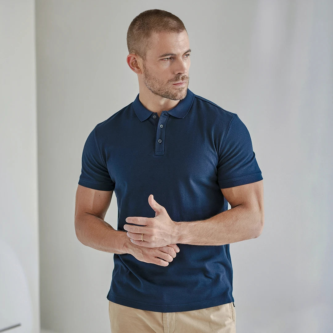 A man wearing a navy French Polo T-Shirt with short sleeves, a collar, and button-up neck.