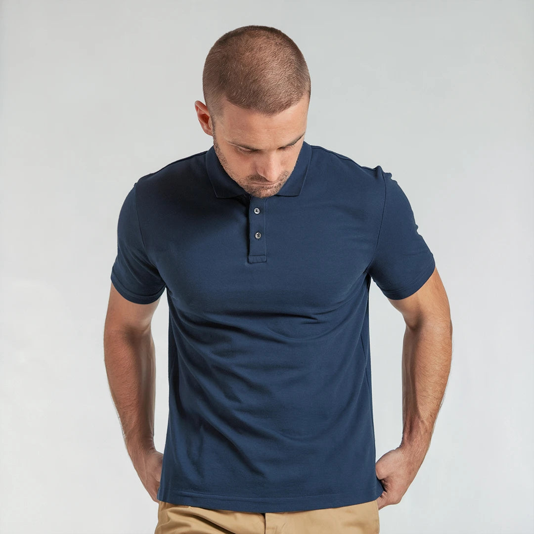 A man wearing a navy French Polo T-Shirt with short sleeves, a collar, and button-up neck.