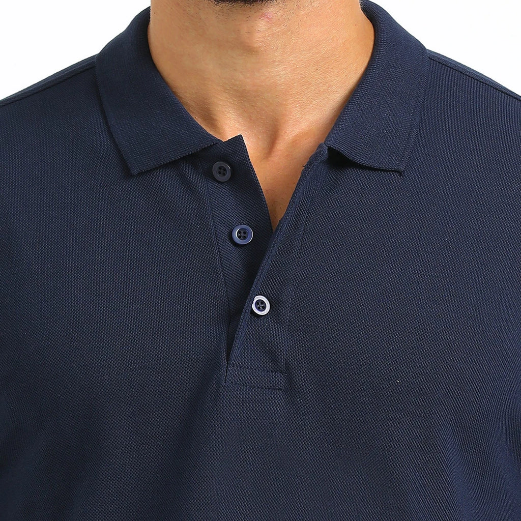 A man wearing a navy French Polo T-Shirt with short sleeves, a collar, and button-up neck.